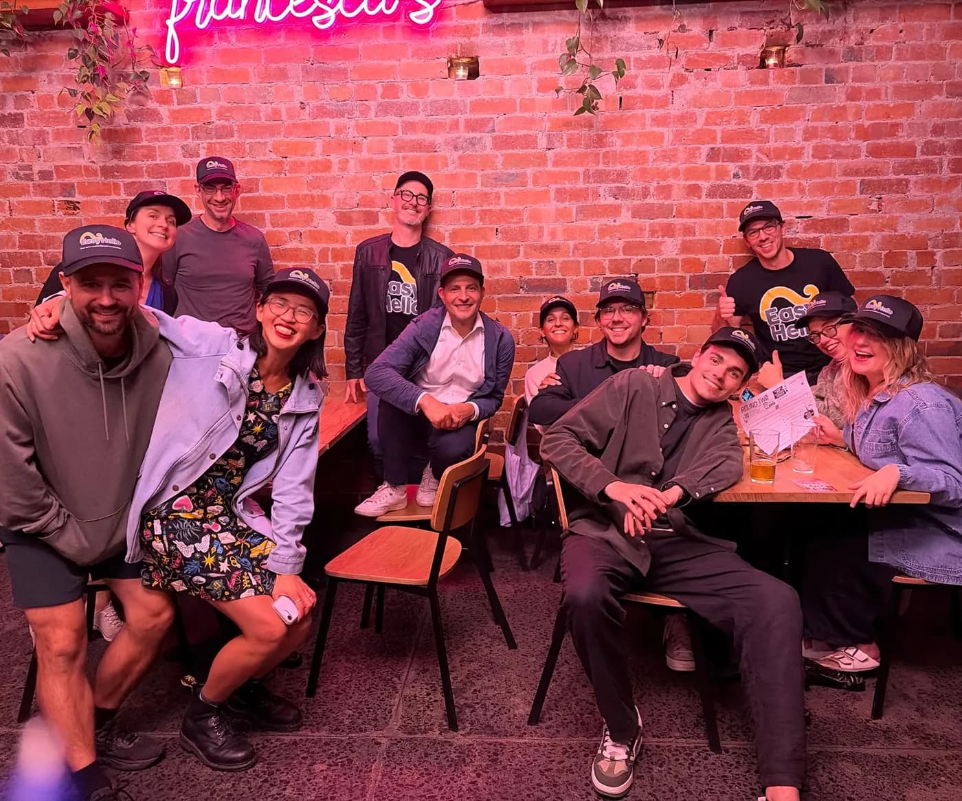 A group of Easy Hello members in matching caps at a trivia night